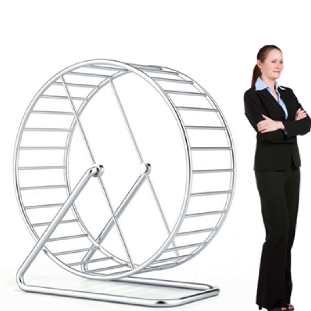 Smiling business owner standing next to a large hamster wheel