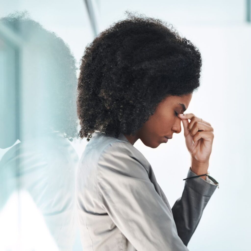 Woman in a business suit expressing stress and frustration, reflecting the challenges of hiring and onboarding processes in a corporate environment.