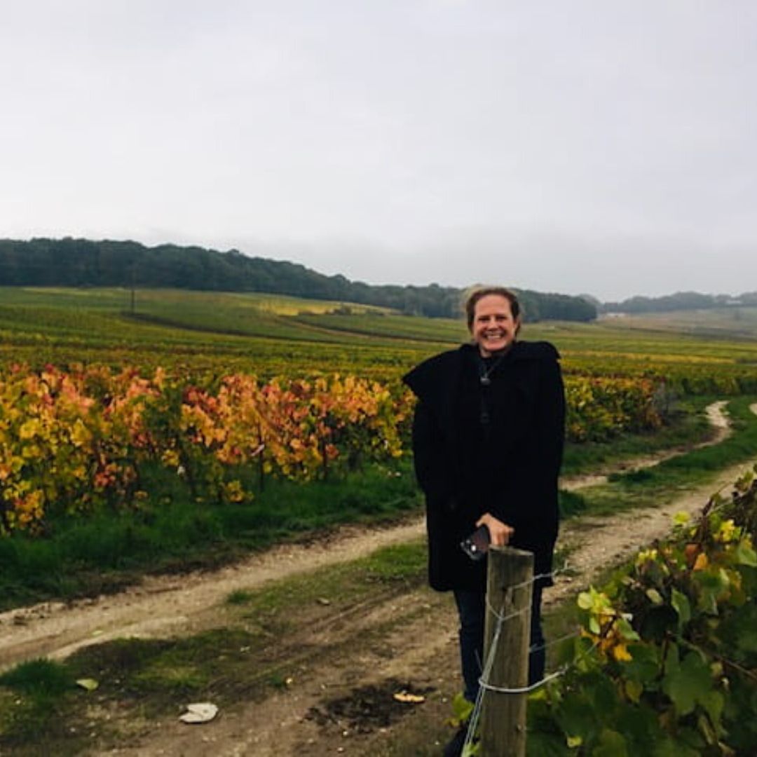 Kristen David, CEO of Upleveling Your Business, standing by a field of flowers in France