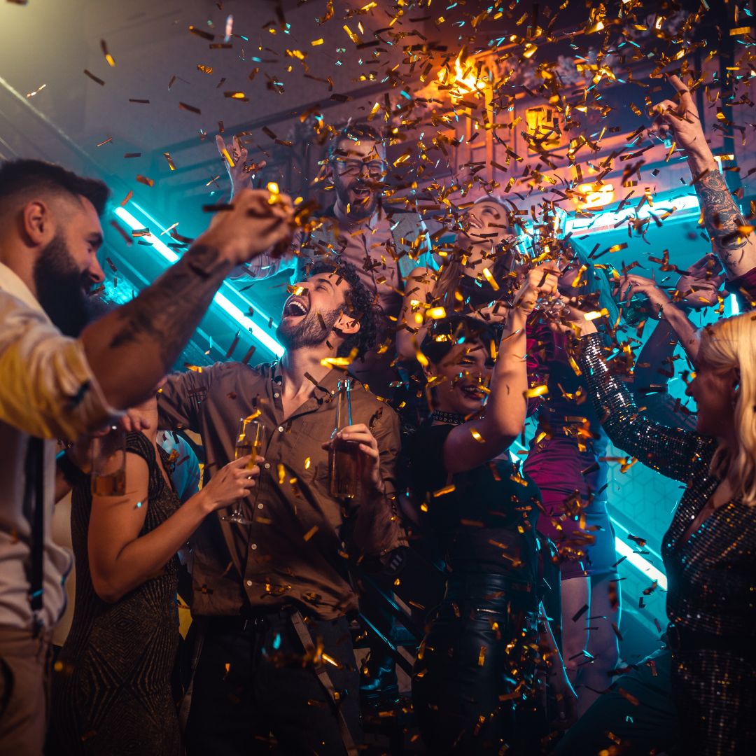 A group of people at a party with streamers and confetti
