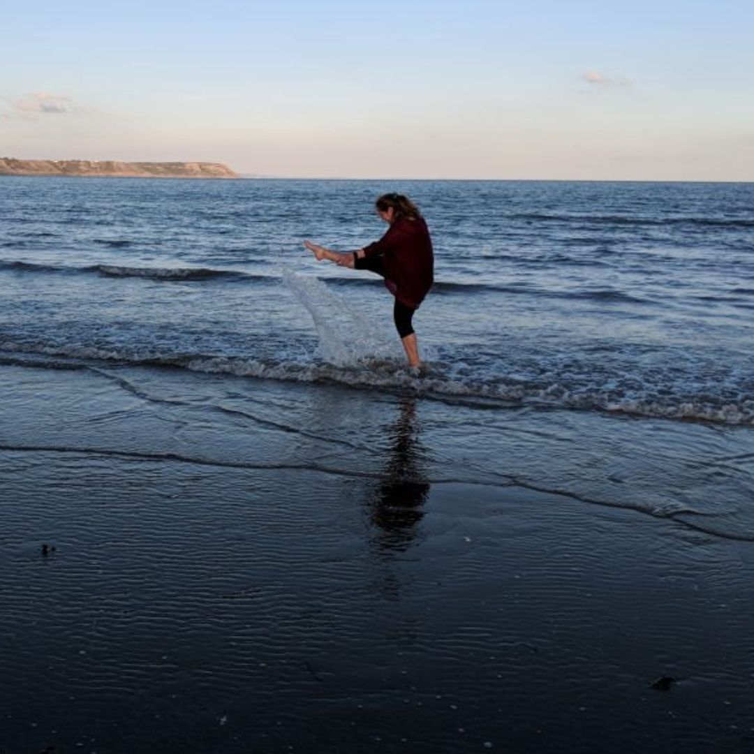Kristen David, CEO of Upleveling Your Business, playing along the Seattle shore