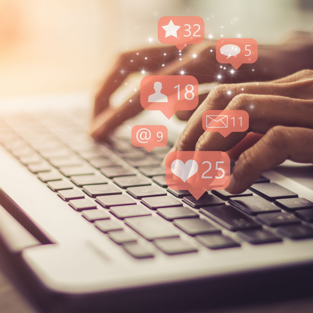 Person typing on a laptop with social media notifications, including likes, messages, and mentions, symbolizing online engagement and remote work.