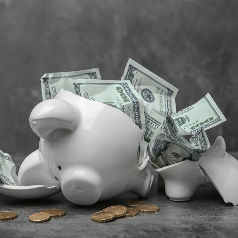Broken piggy bank with money laying on a table