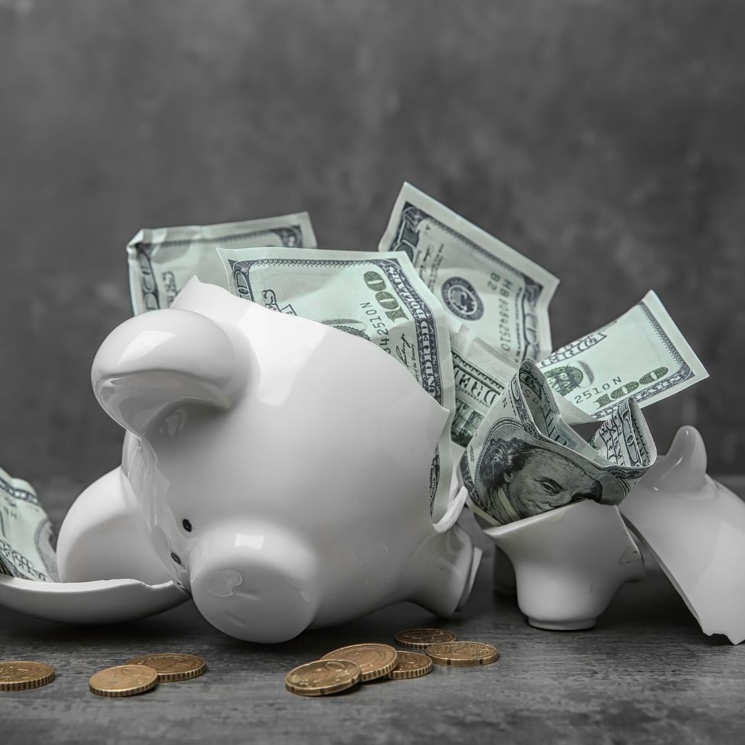 Broken piggy bank with money laying on a table