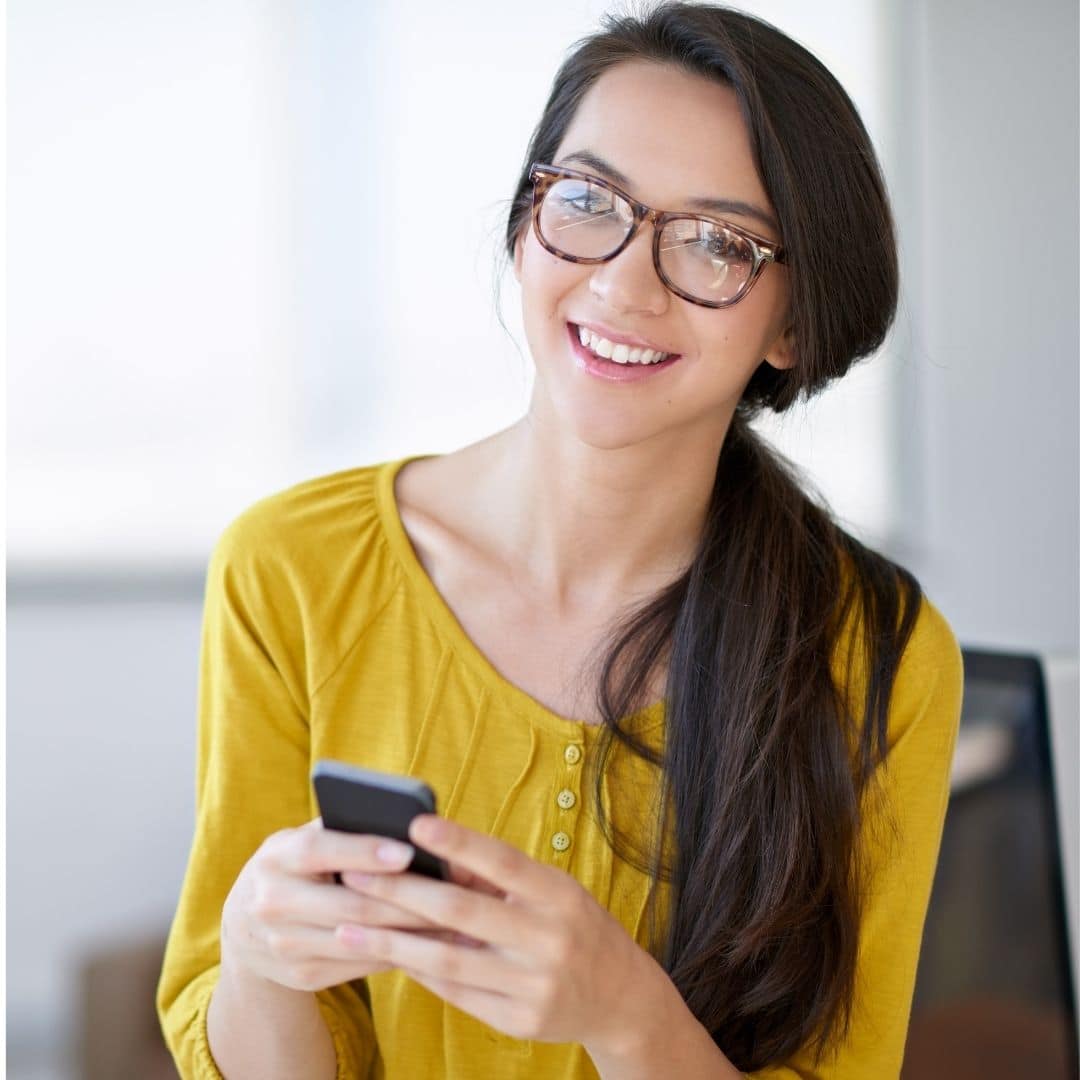 Smiling client service representative in a yellow blouse with a laptop