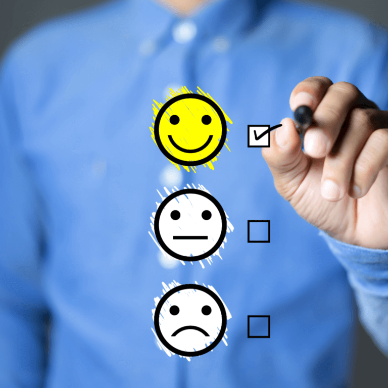 Person in blue shirt marking a happy face on a feedback chart, symbolizing client satisfaction and positive mindset in business.