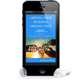 Smartphone displaying the book "Uplevel Your Business, Uplevel Your Life!" by Kristen David, featuring gears symbolizing successful business management, with earbuds beside it.