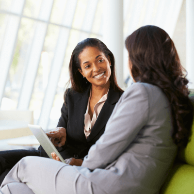 A business owner and executive assistant discussing a project