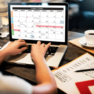 businesswoman filling in a calendar on a laptop