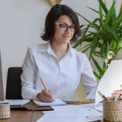 Business woman in a white shirt planning out business goals