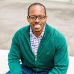 Coach Terrell smiling in a green sweater, representing Upleveling Your Business’s commitment to tailored coaching and team excellence.