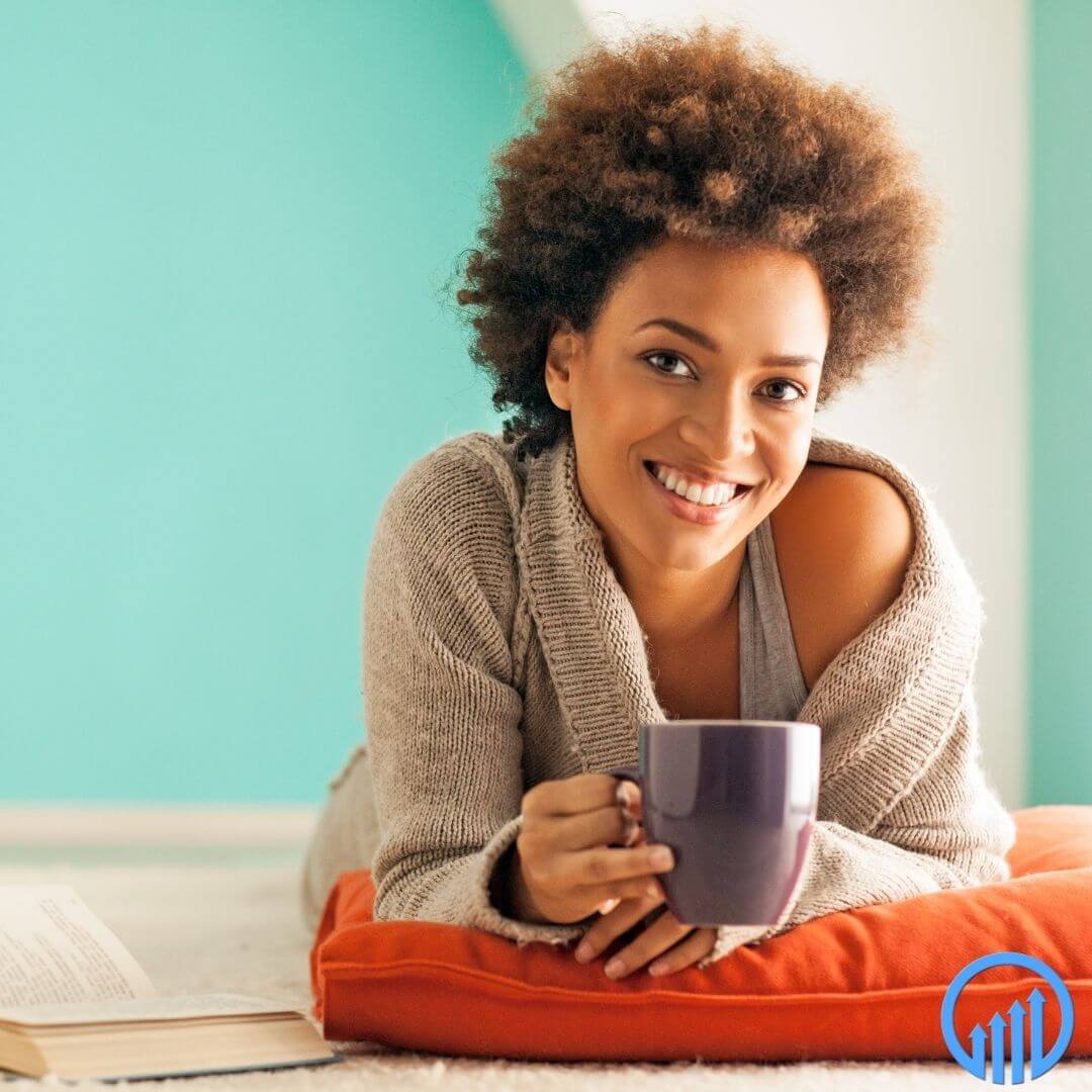 happy professional African American woman relaxing with a cup of coffee and a book