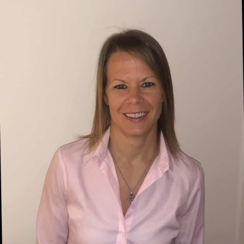 Shannon Casey, culture and management coach, smiling in a pink blouse against a neutral background, representing her expertise in coaching and leadership.