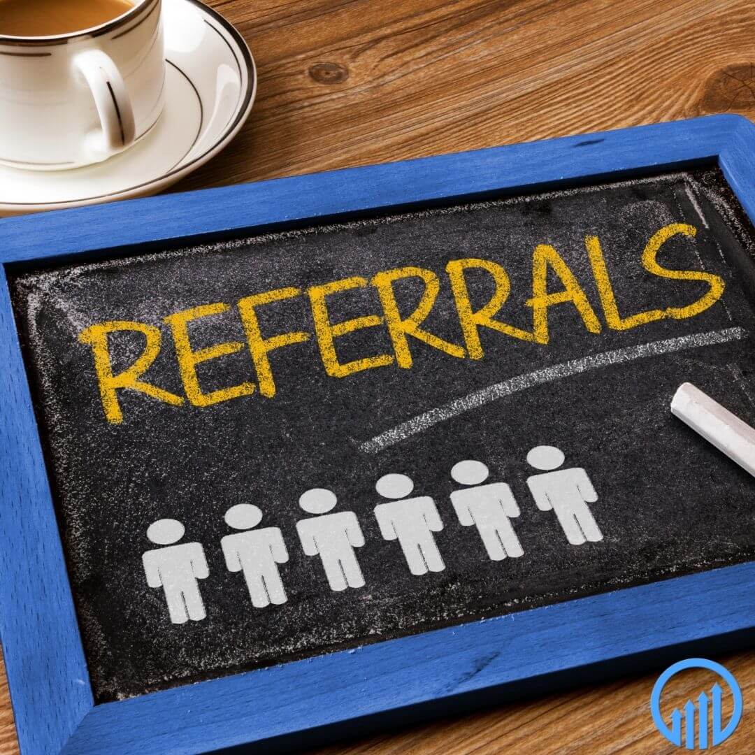 Framed small blackboard with "referrals" and stick figure people drawn on it