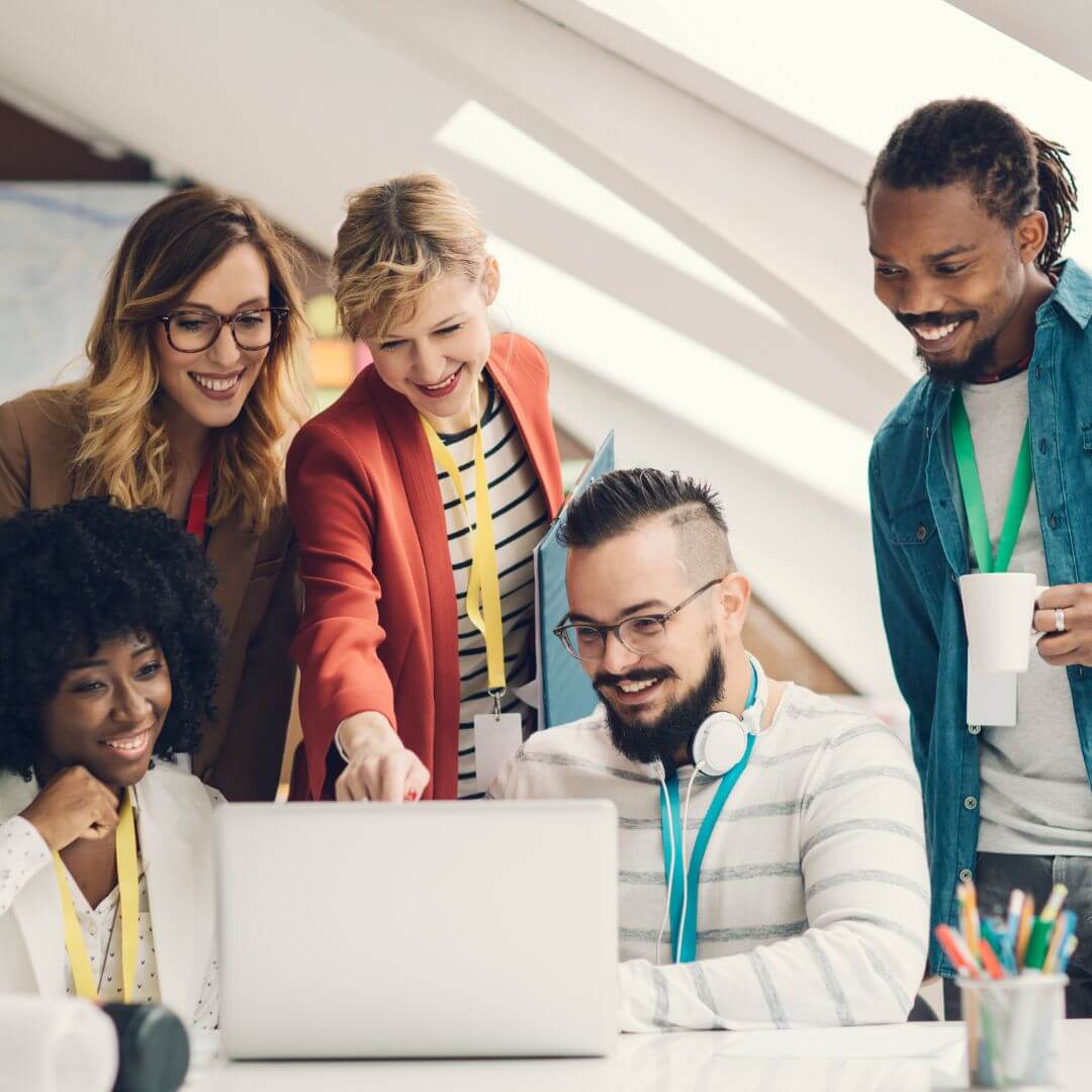 diverse team collaborating around a laptop