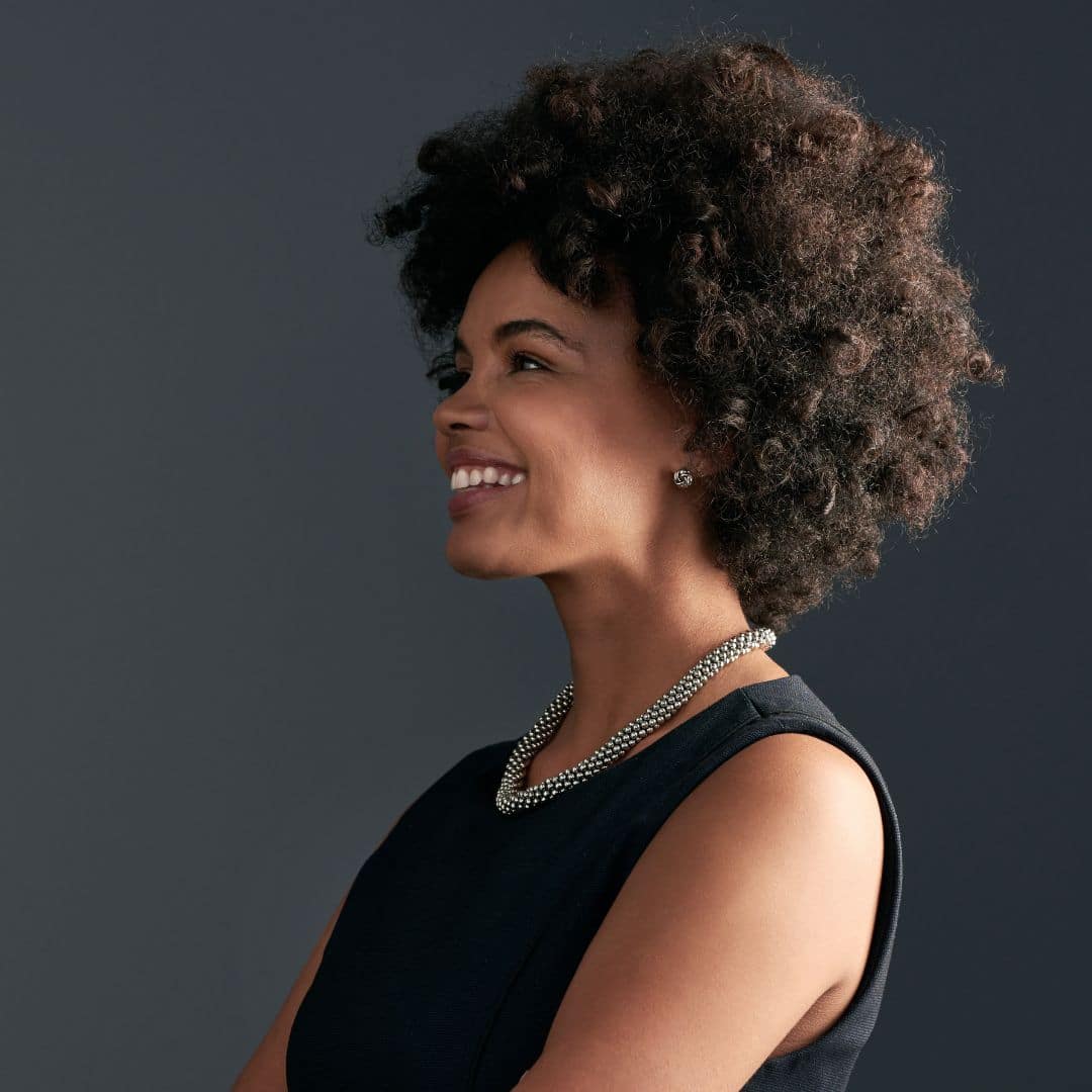 confident African-American woman against a gray backdrop, smiling