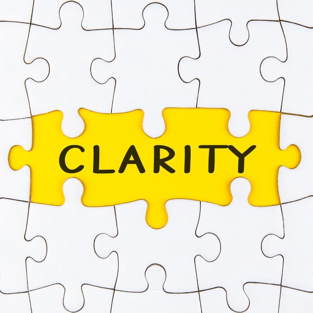 Puzzle piece with the word "CLARITY" in bold, yellow font, representing the importance of clear metrics and goals in a data-driven business culture.