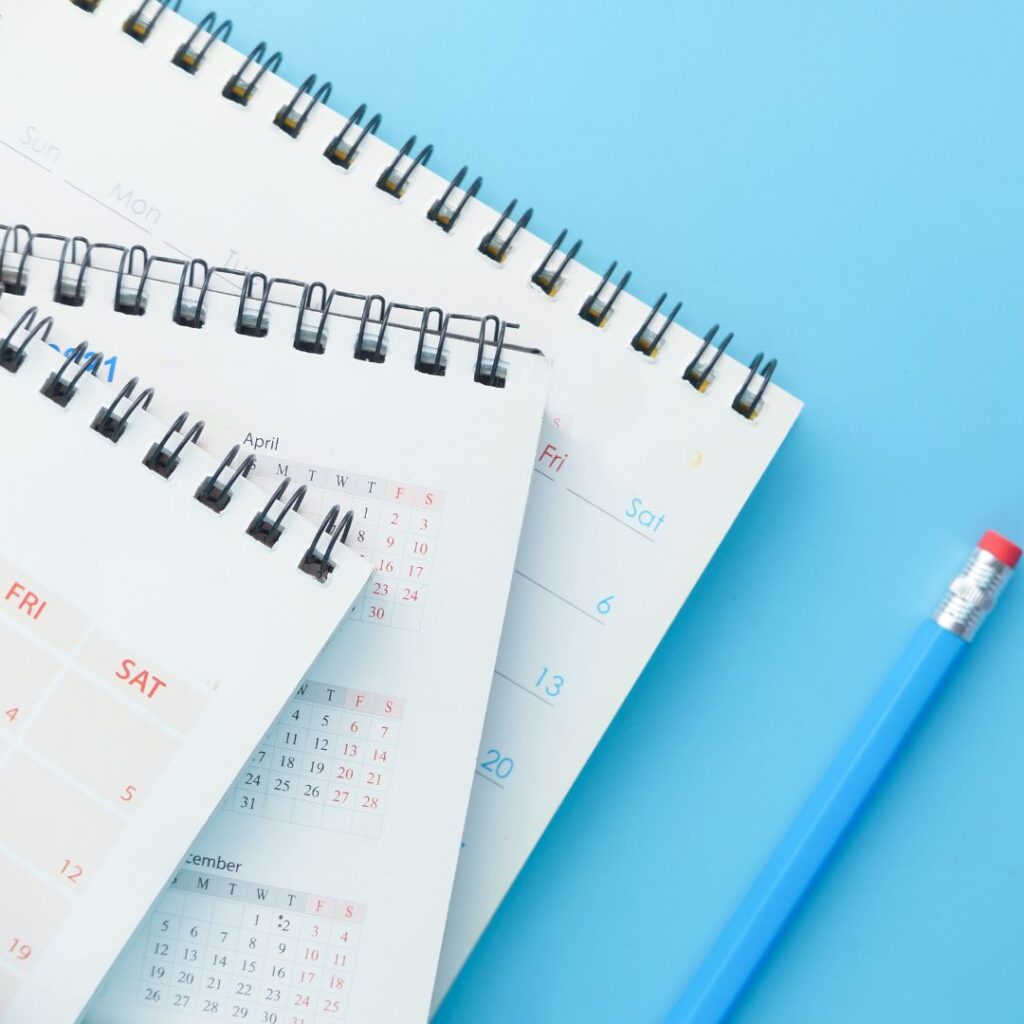 Calendars stacked on a blue background, symbolizing planning and organization for marketing strategies and training sessions.