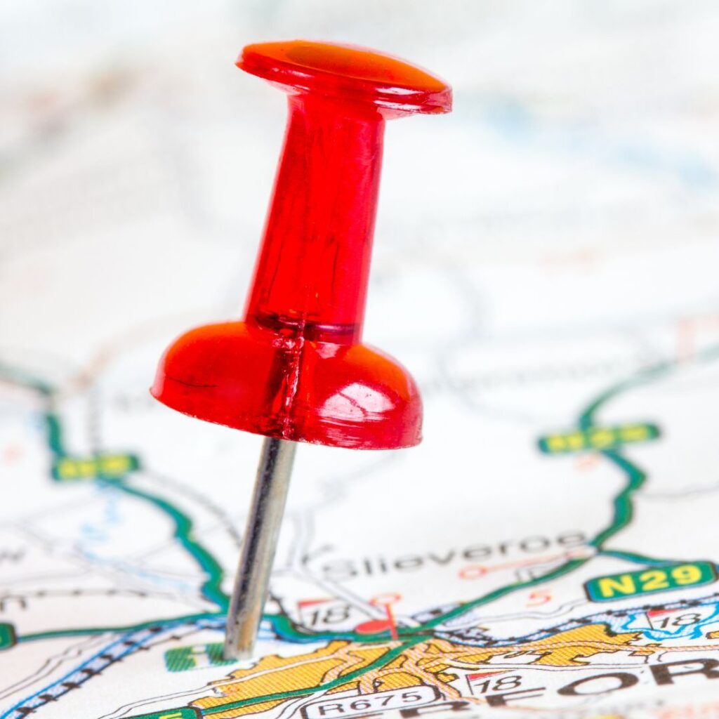 Red pushpin on a map, symbolizing focus and direction for marketing strategies and team training in Upleveling Your Business's Marketing Boot Camp.