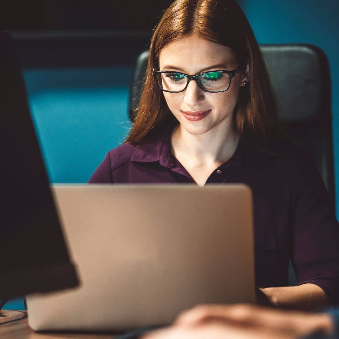 A professional woman working at a laptop