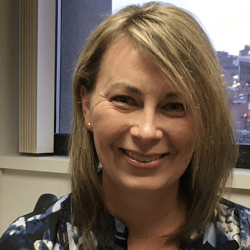 Pamela Coward, Implementation Coach at Upleveling Your Business, smiling in a professional setting, showcasing her approachable demeanor and expertise in behavioral health and goal-setting.