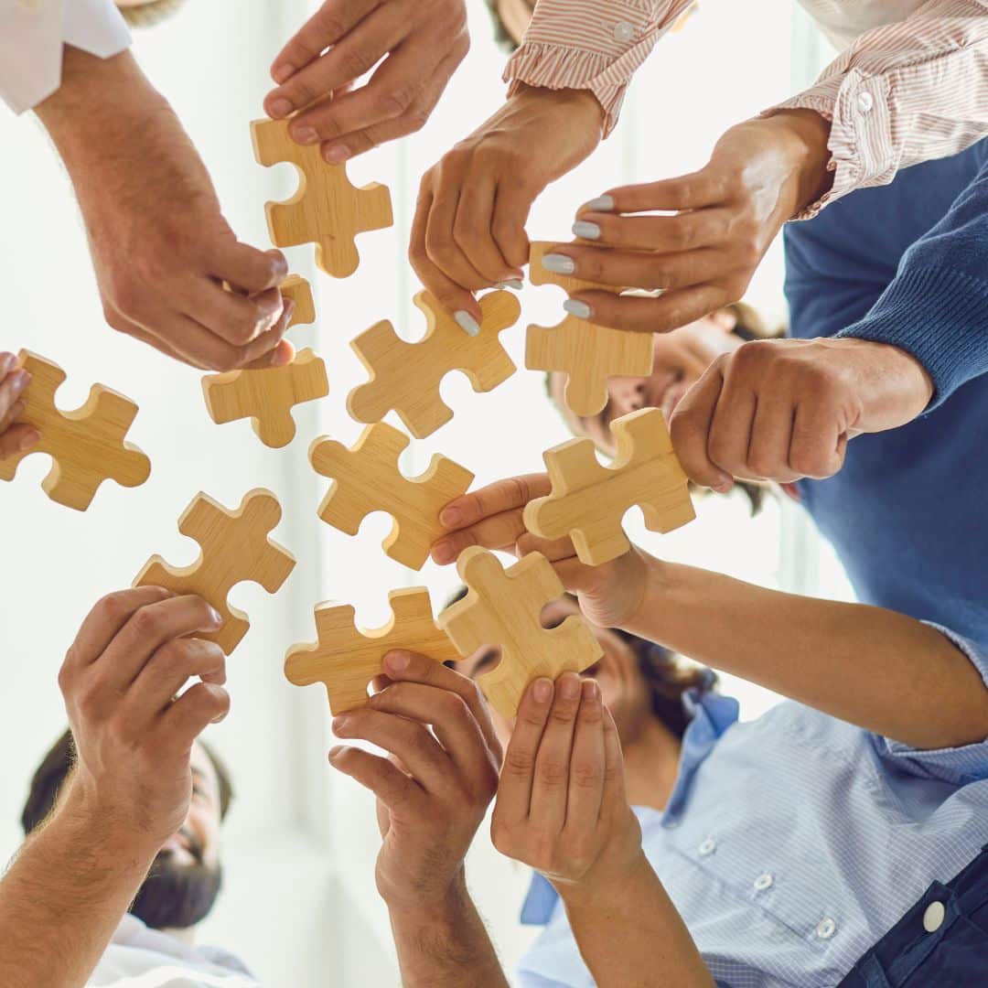 A team of people putting large puzzle pieces together.