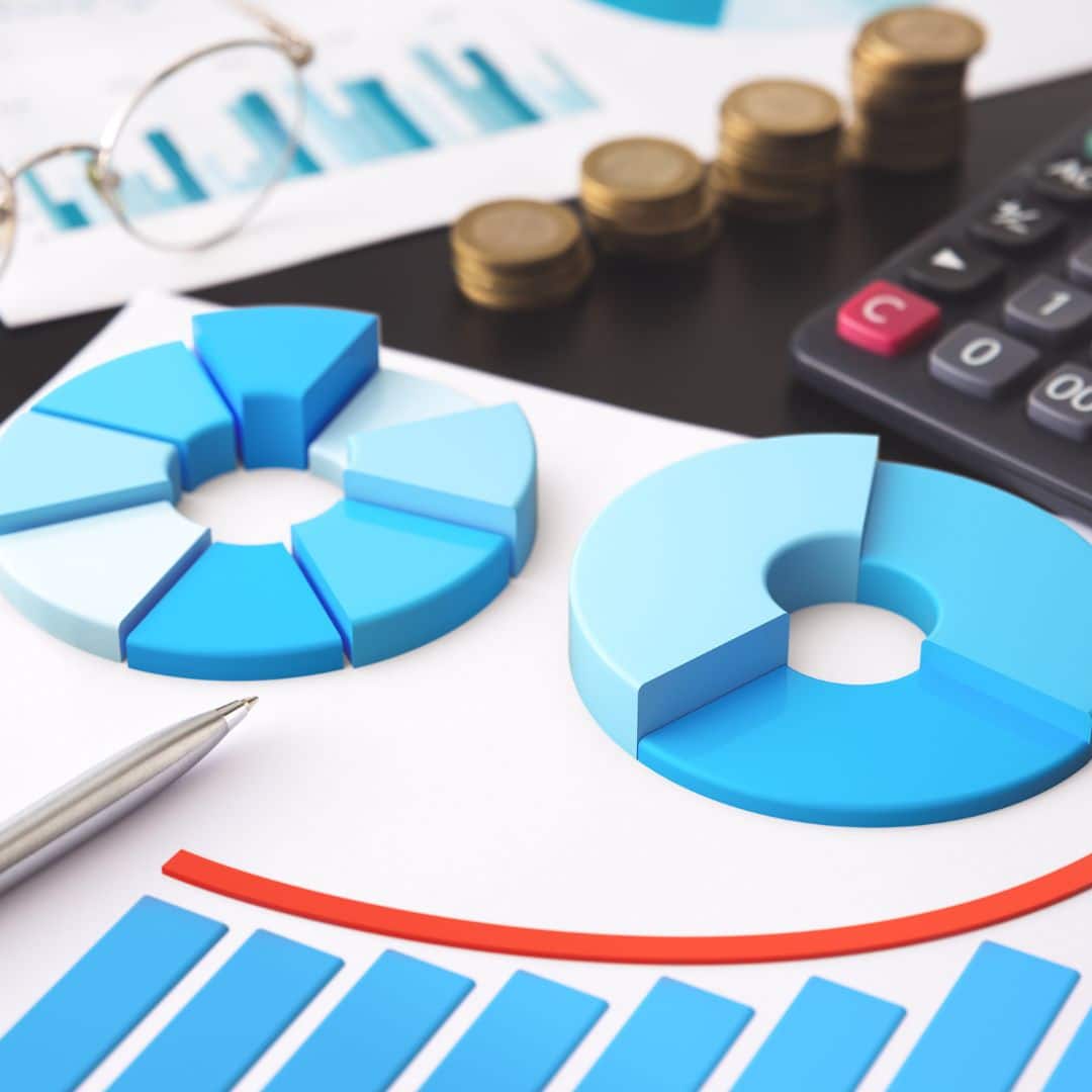 Pie charts and bar graphs in blue tones on financial documents, with a calculator and coins, illustrating business analytics and operational efficiency.
