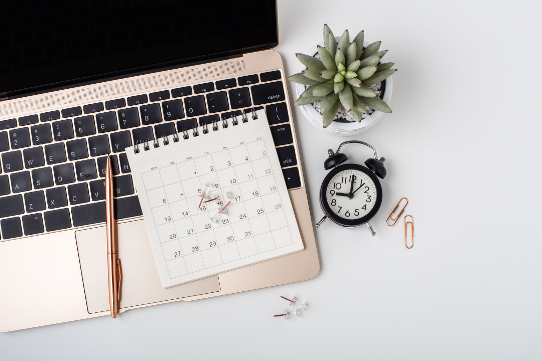 Laptop with calendar, clock, succulent plant, and stationery, symbolizing project management and organizational efficiency in business.