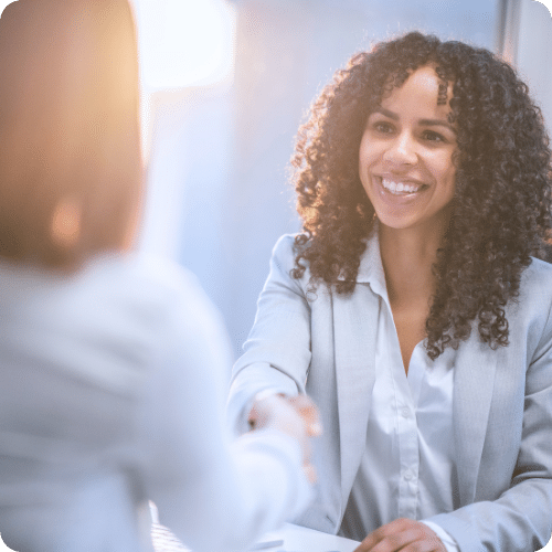 Client Engagement Specialist smiling and shaking hands with a client, illustrating personal interaction and rapport-building in a professional setting.