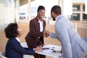 Business professionals engaging in a handshake, demonstrating effective client relationship building and customer service strategies.
