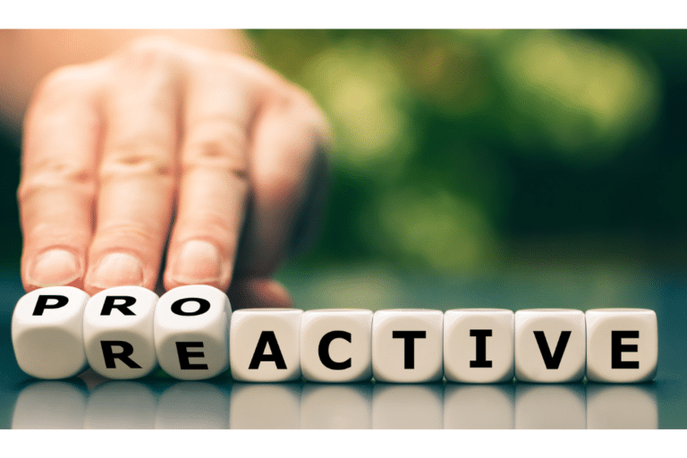 Hand pushing lettered blocks spelling "PROACTIVE" and "REACTIVE," symbolizing a mindset shift for business success.