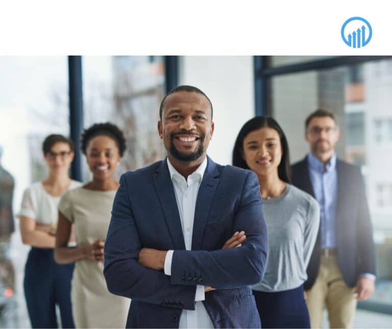 Diverse group of professionals smiling and standing together in a modern office, representing teamwork and business growth for year-end planning.