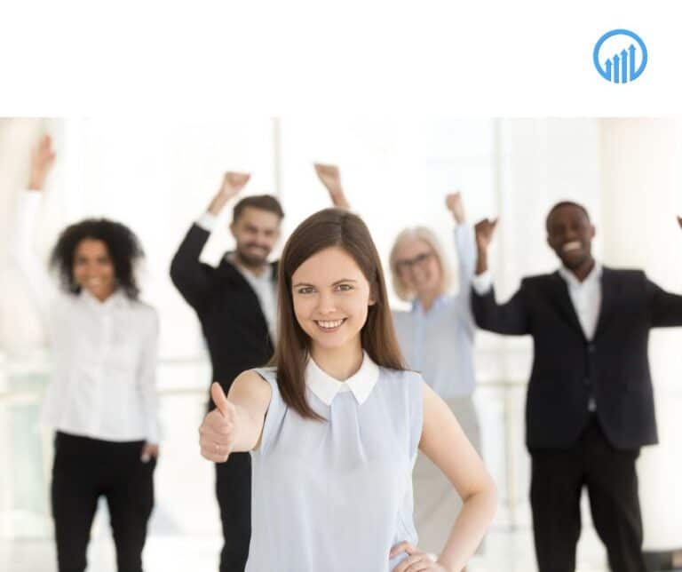Smiling woman giving a thumbs-up, surrounded by a diverse group of happy colleagues celebrating success in a bright office setting, symbolizing teamwork and positive business planning.